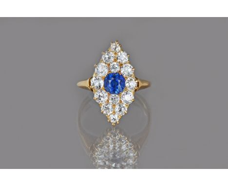 A gold, sapphire and diamond marquise shaped cluster ring, mounted with the cushion shaped sapphire at the centre and otherwi