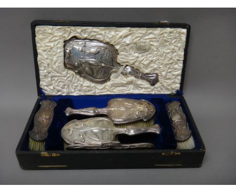 A silver mounted Art Nouveau composite six piece lady's dressing set, each piece decorated with birds, flowers and water lili