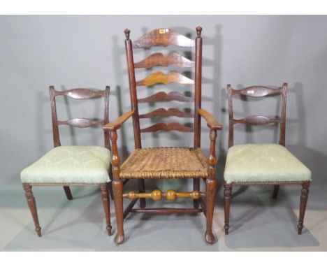 An early 19th century American cherry wood ladder back, open armchair and a pair of Regency mahogany bar back dining chairs, 