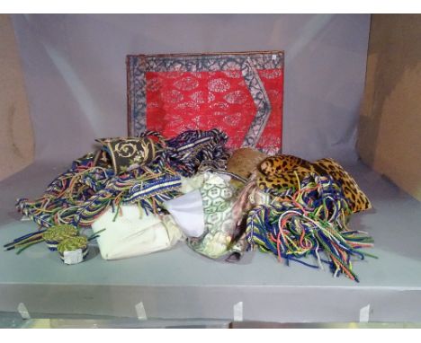 Textiles including; a stretched patterned panel, lace panels, leopard print cushions, tassels and sundry, (qty). 