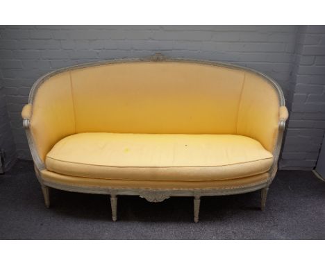 A Louis XVI style tub back sofa, with cream painted moulded frame, on tapering fluted supports, 180cm wide x 104cm high. 
