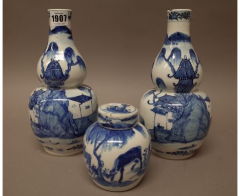 A pair of Chinese blue and white double gourd vases, circa 1900, each painted with a river landscape with figures leading a b