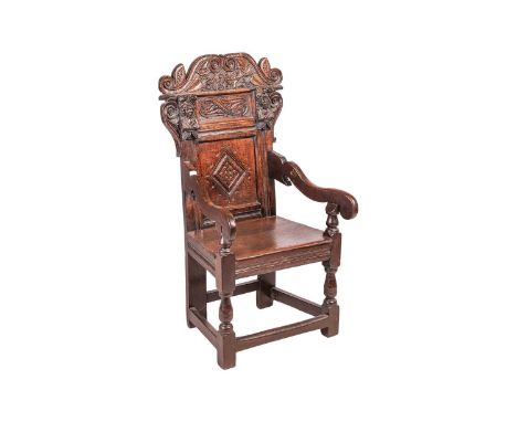A Charles II and later oak wainscot armchair with scroll-carved cresting rail, above a pair of figural brackets depicting Cha