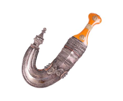 An amber-handled jambiya, with gold applique and beaded girdle, fitted with a decorative silver scabbard inscribed with Arabi
