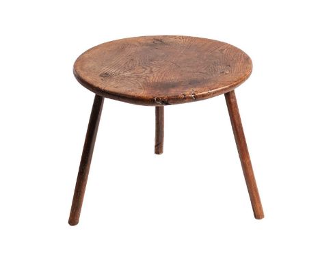A 19th-century primitive figured elm circular cricket table, probably Welsh, the thick well-figured top fitted with simple he