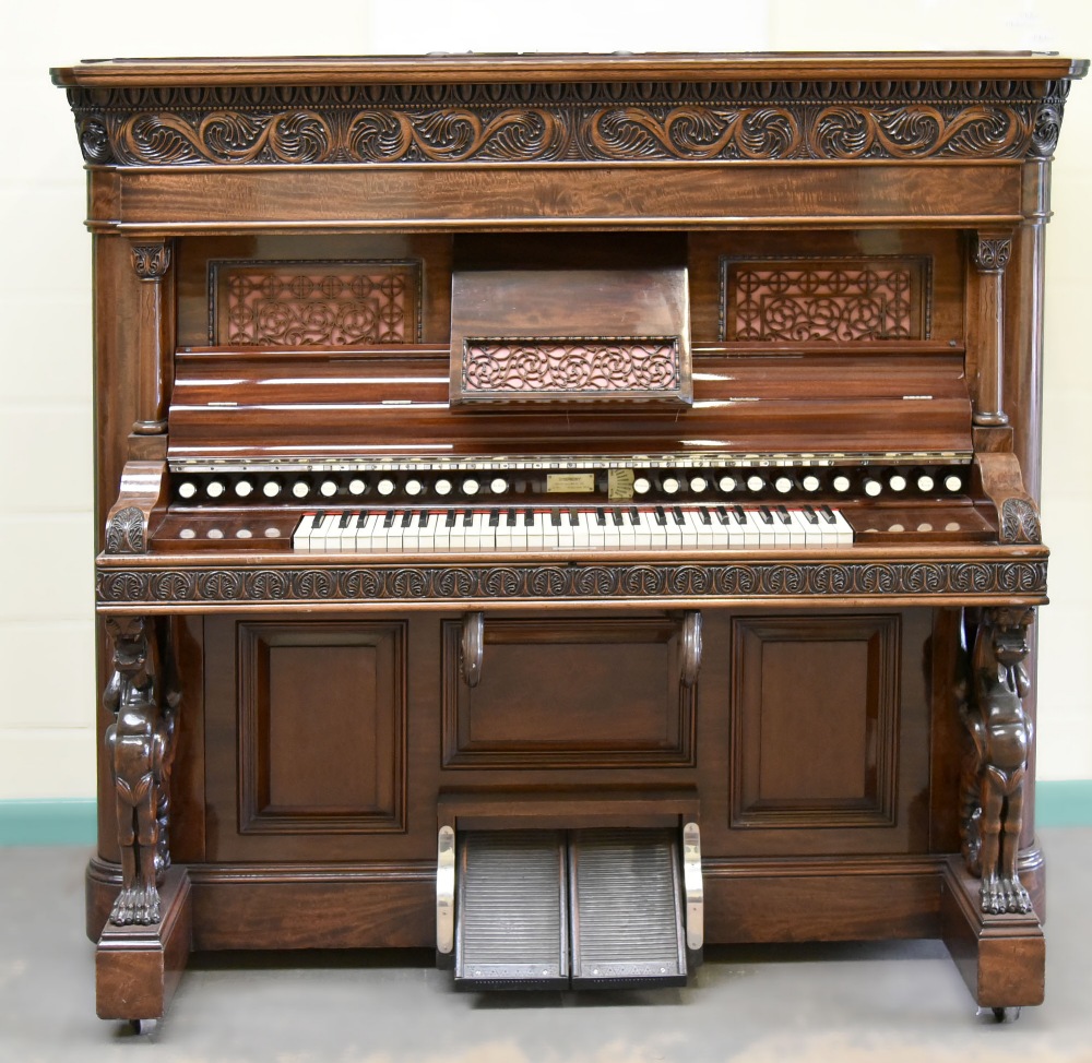 A 1901 Wilcox & White harmonium organ with roll play in a carved and