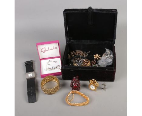 A black velvet jewellery box containing an assortment of costume jewellery such as necklaces, decorative bangle, brooches, et