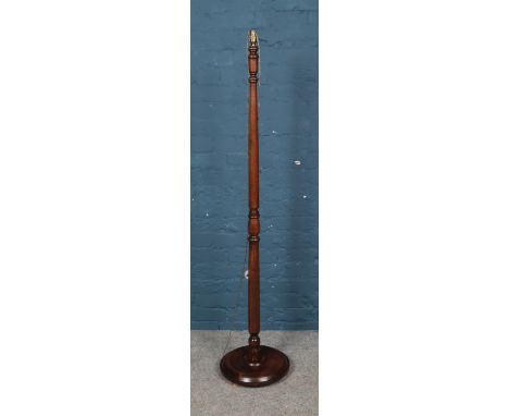 A turned mahogany standard lamp on circular base. Missing shade.  