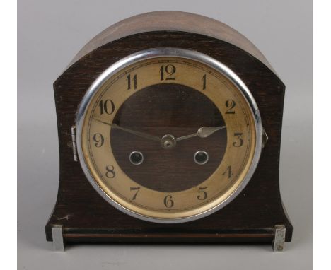An oak dome shape mantel clock. Chiming on coil gong with key and pendulum.  
