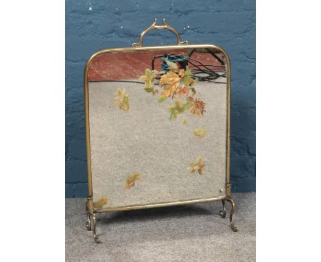 A brass mirrored fire screen featuring painted autumnal leaf decoration.  