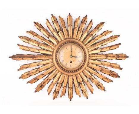 An Art Deco starburst wall clock, with gold roman numeral dial, gilt wood, 55cm wide x 41 cm high. Condition Report: dial dia