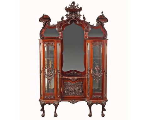A 19th century carved mahogany display cabinet, the mirrored back with elaborate carved and scrolled pediment, with shelves o