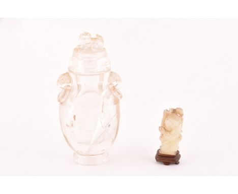 A Chinese carved rock crystal vase and cover, the cover crested with a carved dog of foe, the vase with elephant head and rin