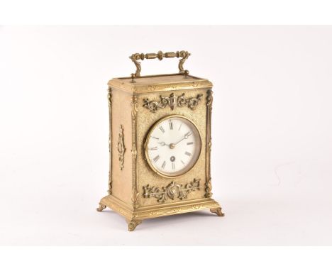 A 19th century French brass mantel clock, with ornate relief decoration and engraved detail, the white dial with roman numera