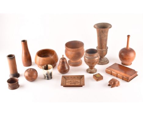 A collection of assorted carved wooden treen items, including vases, cups, bowls, carved fruit, a carved frog, a carved book,