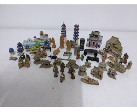 A collection of Chinese ceramic mudmen, buildings, bridges and pagodas figurines, a porcelain model of a pagoda and bridge, a