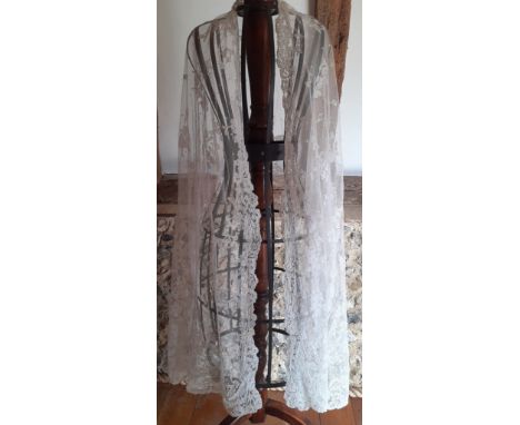 An early 20th Century Irish white lace veil on button mesh ground, possibly Carrickmacross lace, images of floral sprays and 