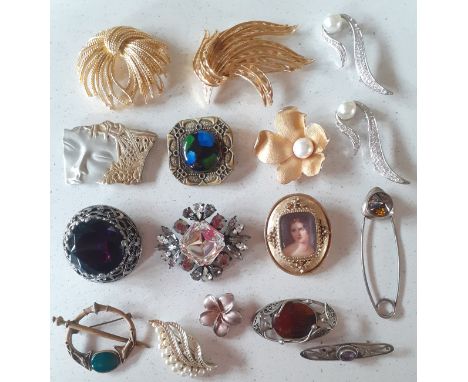 A collection of vintage brooches to include a Mexican silver Geisha face brooch, large Monet gold brooches and a Miracle silv