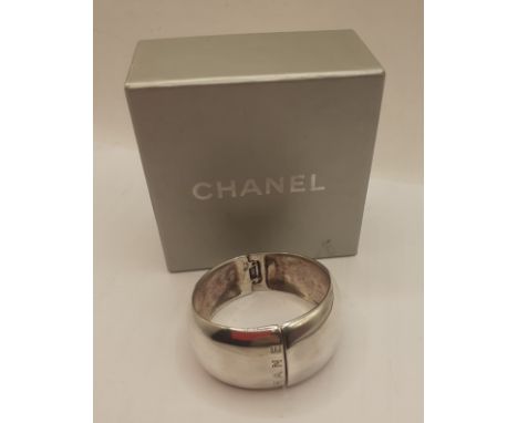 Chanel-A wide silver cuff bangle branded towards the opening and to the hinge, stamped 925 with grey branded jewellery box. L