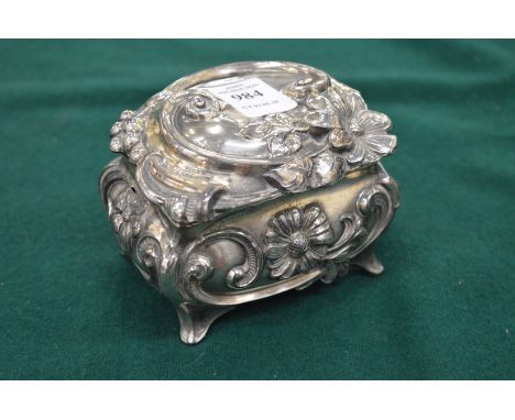 A silver plated ornate casket with hinged cover.
