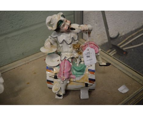 An amusing Continental porcelain box and cover modelled as a colourful musician seated on a drum with a dog by his side.