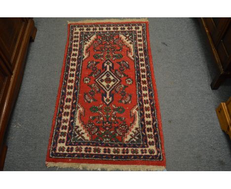 A small Persian design rug, 132cm x 69cm.