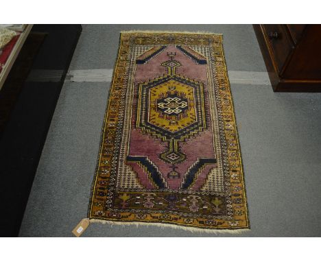 A small Persian rug, purple ground with geometric decoration, 155cm x 86cm.