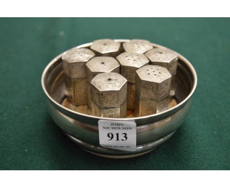 Silver wine coaster and a group of Eastern white metal salt and peppers.