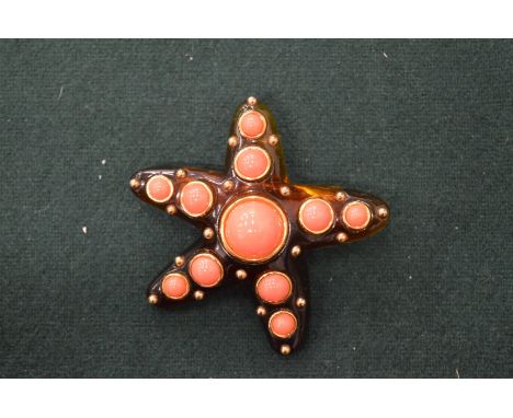 A Kenneth Lane faux tortoiseshell and coral starfish shaped brooch.