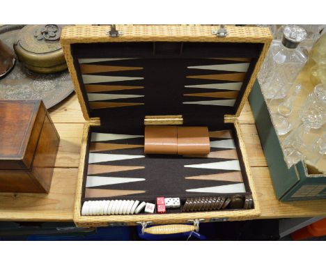 A wicker travelling backgammon set.