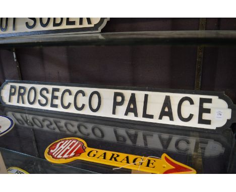 A novelty carved wood and painted sign 'Prosecco Palace'.