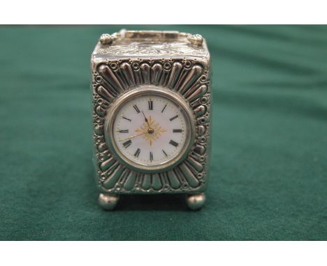 A good small embossed silver and enamel carriage clock.