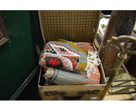 A small trunk containing three various carpets/wall hangings.