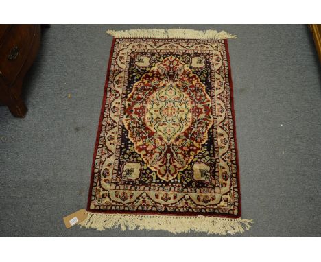 A small Persian design rug, red ground with floral decoration, 93cm x 61cm.