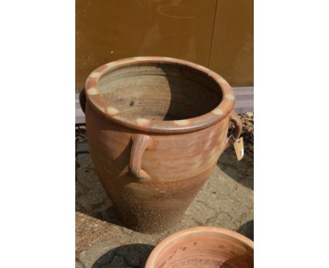 A very large glazed earthenware planter with strap work handles.