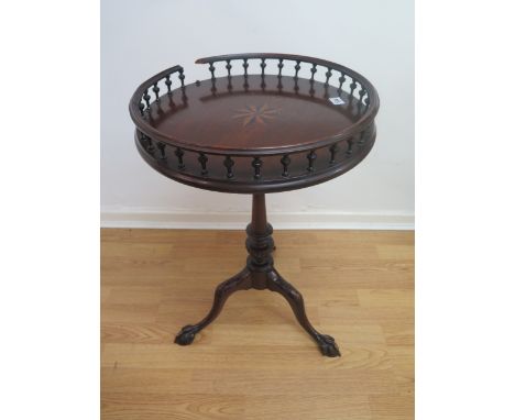 A mahogany wine table with a star inlaid galleried top, tilting birdcage action on a carved tripod base, break to gallery som