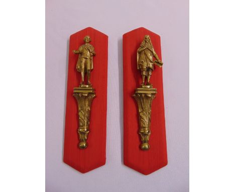 Two cast ormolu figurines in 17th century attire on leaf chased prints mounted on red fabric panels