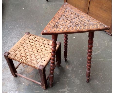 A decoratively carved triangular side table with bobbin legs, along with a small rush foot stool