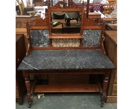 An Edwardian hall side table raised on casters with grey marble top and back, with ceramic tiles and bevelled glass mirror, 1