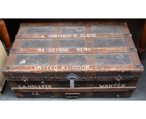A travel trunk with metal and timber bracing containing a number of lamp shades