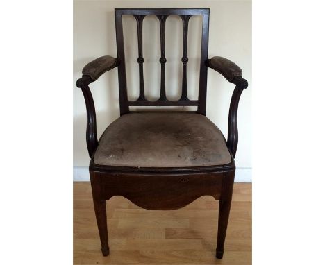 A Victorian open arm commode chair, raised on tapered legs below a shaped apron