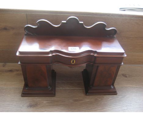 A 19th mahogany tea caddy modeled as a twin pedestal sideboard. The top opening to reveal a central section and two lead line