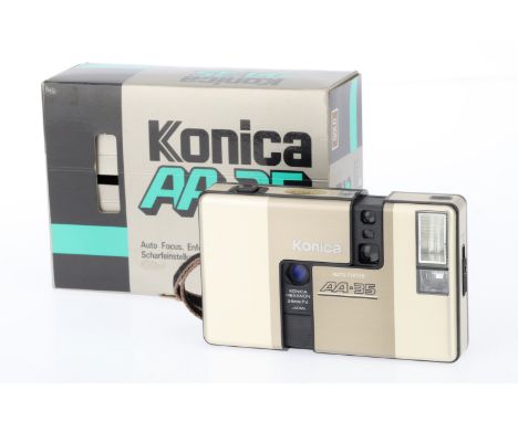 A Konica AA-35 Compact Half Frame Camera, pale gold, body G, evidence of battery leakage, small bump to front case, motor dri