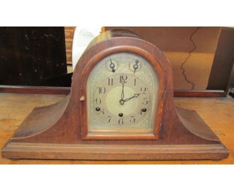 An oak cased mantle clock, with a silvered dial and Arabic numerals