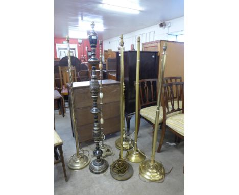An Islamic black and gilt metal standard lamp and six other brass standard lamps 
