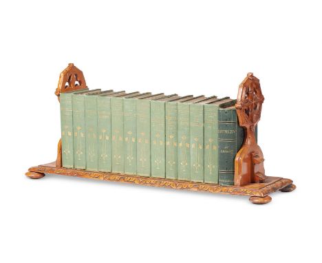 A VICTORIAN ADJUSTABLE BOOKSHELF   LATE 19TH CENTURY   Stained softwood with Gothic carved supports on squat bun feet togethe