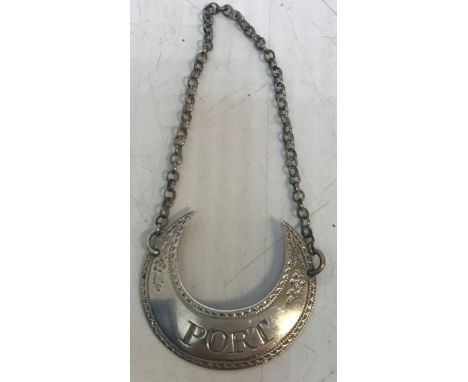 A George III silver wine label inscribed "Port" in the form of a crescent with cut bright floral decoration bears makers name