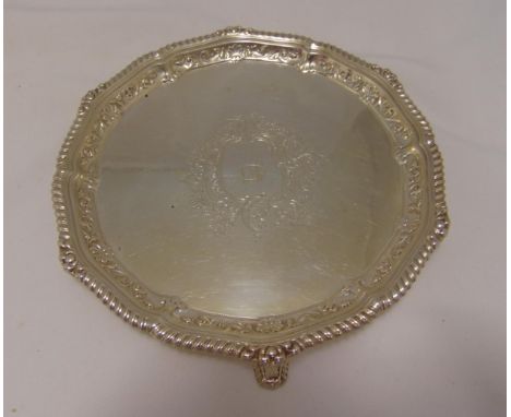 A hallmarked silver salver, circular with gadroon and shell border on three bracket feet, London 1903 by George Jackson and D
