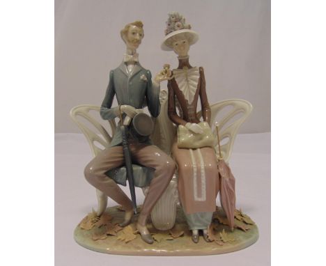 Lladro figural group of a gentleman and lady seated on a bench, marks to the base, 30 x 26cm