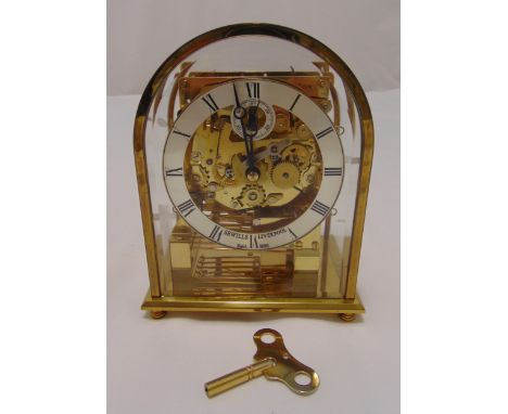 Sewells of Liverpool gilded metal skeleton mantle clock with arched top, silvered dial and Roman numerals, on bun feet, to in
